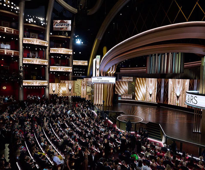 Oscar ceremony venue filled with attendees, showcasing the grand stage and elegant decor. Oscar ceremony venue filled with attendees, showcasing the grand stage and elegant decor.