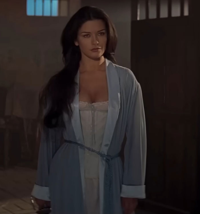 A woman in a light blue robe stands indoors. Actors often discussed for being challenging to work alongside.