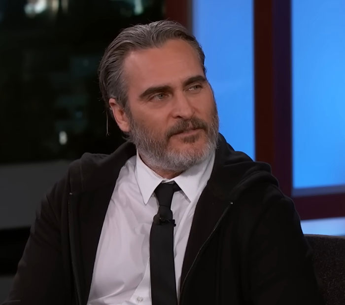 A bearded actor in a suit and tie on a talk show set, discussing his career.