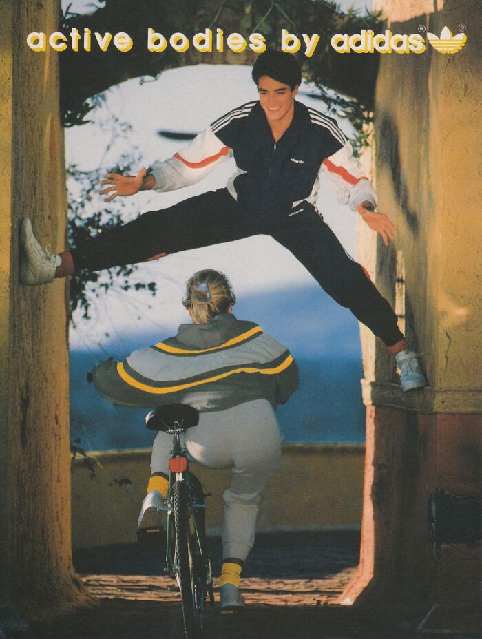 Adidas tracksuit advertisement featuring a person leaping over a cyclist, evoking vintage-commercials style.