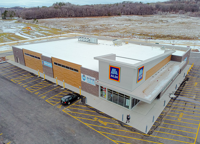 Aerial view of Aldi store with a sign referencing a controversial kids' toy, parking lot visible.