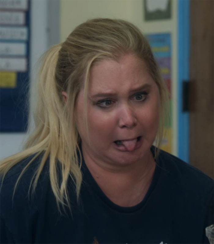 Blonde woman making a funny face, sticking her tongue out, in a comedic setting.