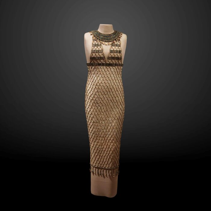 Ancient civilizations artifact: a beaded dress on a mannequin with intricate patterns, showcasing historical craftsmanship.