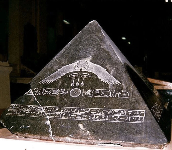 Ancient artifact with hieroglyphs on a pyramid shape, showcasing ancient civilizations' art and symbols.