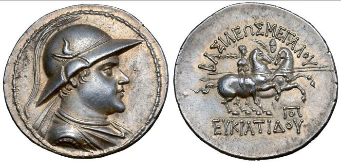 Ancient civilizations artifact: a silver coin depicting a helmeted warrior on one side and a horseman on the other.