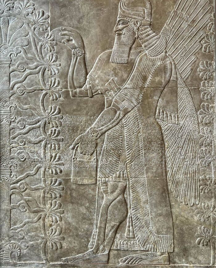 Ancient civilization artifact depicting a winged figure carved in stone relief with intricate details.