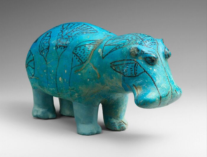 Ancient civilizations artifact: blue glazed ceramic hippopotamus with intricate designs.
