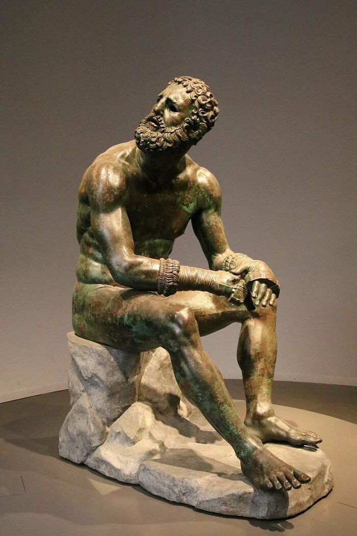 Ancient bronze sculpture of a seated boxer, showcasing artifacts from ancient civilizations.