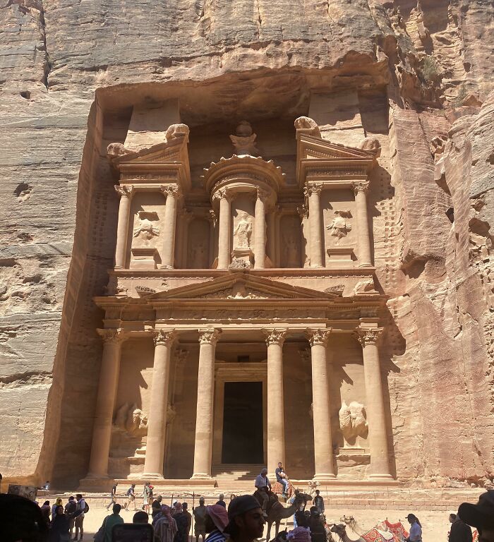 Ancient civilization artifact in Petra, showcasing intricate rock-cut architecture and visitors exploring the site.