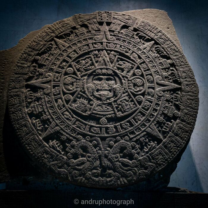 Ancient artifacts: intricately carved Aztec calendar stone showcasing detailed glyphs and symbols, highlighting ancient civilizations.