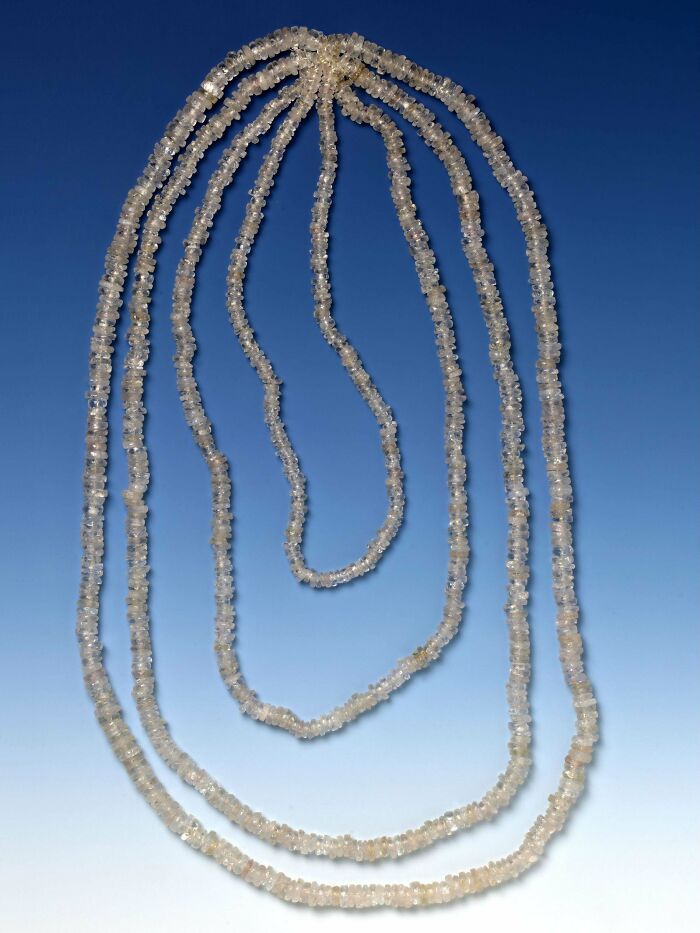 Ancient civilizations' artifacts: a delicate series of translucent beads arranged in multiple strands against a gradient backdrop.