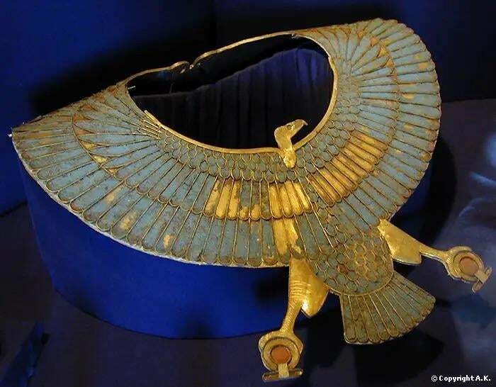 Ancient civilizations artifact featuring an intricate gold and blue falcon-shaped collar on display.