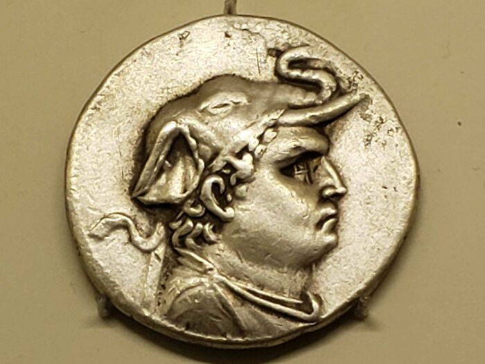 Ancient coin depicting a helmeted figure in profile, illustrating ancient civilizations.
