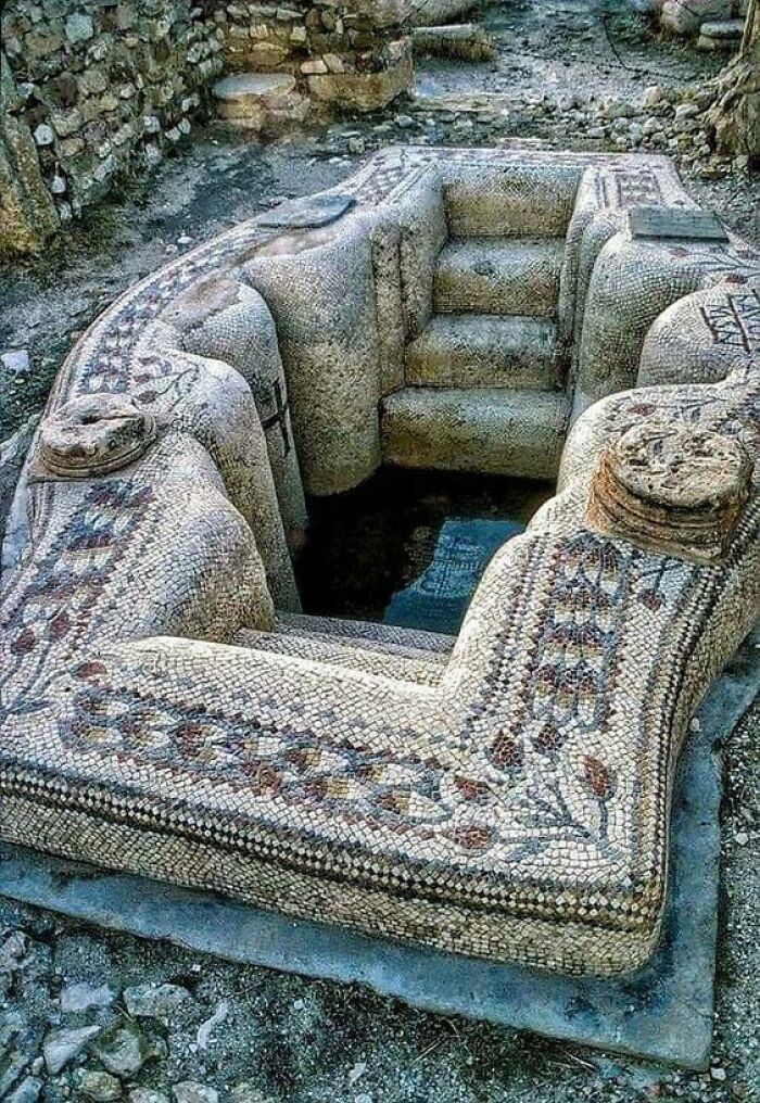 Ancient civilizations' artifact: intricately designed stone mosaic structure with steps, amidst ruins.