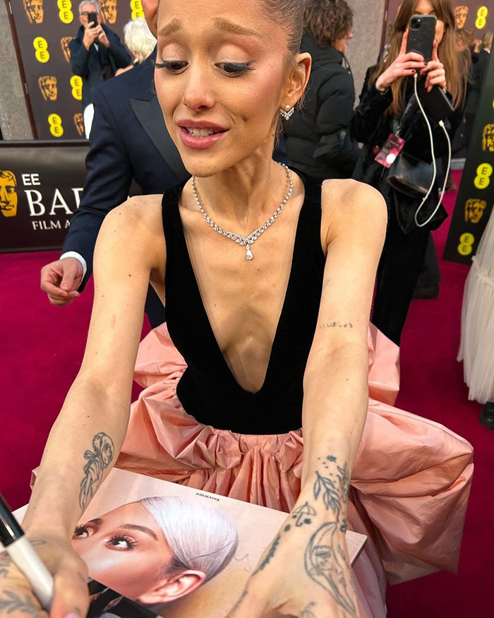 Ariana Grande signing fan's photos and albums at BAFTAs red carpet