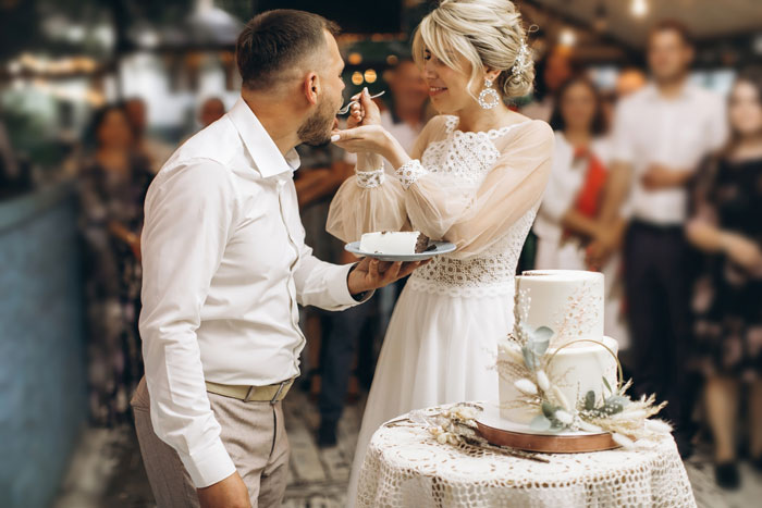 Bride and groom sharing cake at a wedding, highlighting child-free wedding theme. Bride and groom sharing cake at a wedding, highlighting child-free wedding theme.