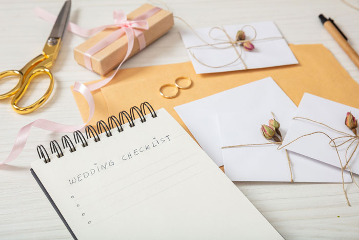 Wedding checklist on a notepad, with rings and gift, symbolizing a child-free wedding planning scene. Wedding checklist on a notepad, with rings and gift, symbolizing a child-free wedding planning scene.