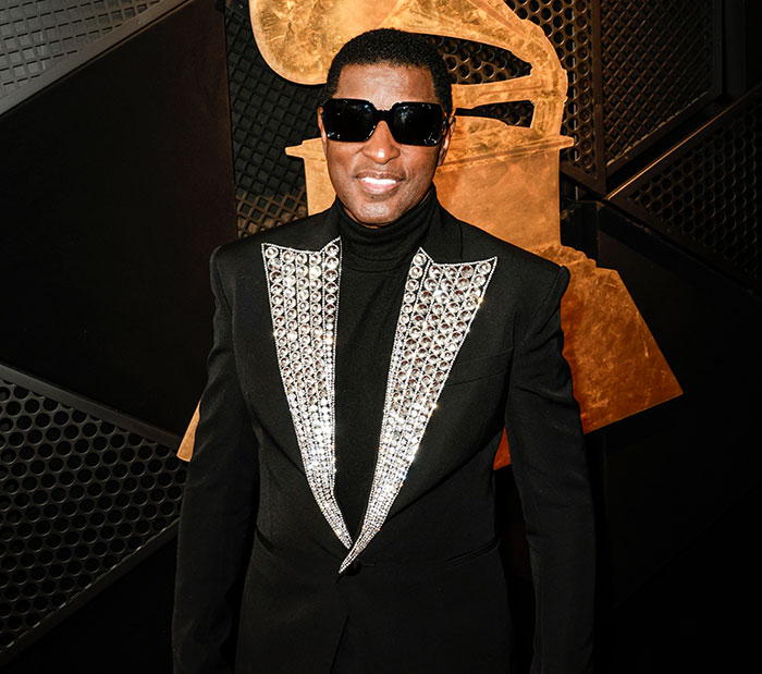 R&B legend in a black and silver outfit wearing sunglasses at the Grammys. R&B legend in a black and silver outfit wearing sunglasses at the Grammys.