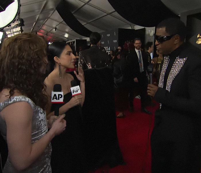 Red carpet interview at the 2025 Grammy Awards, featuring a striking conversation with microphones in hand.