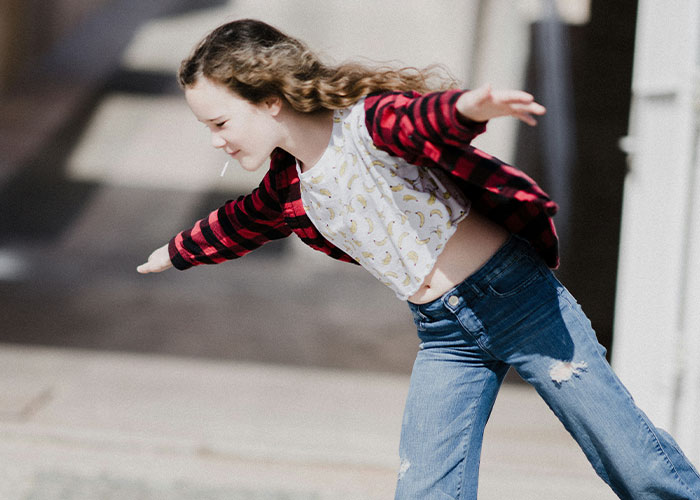 Child playing outdoors in casual clothes, representing carefree childhood moments.