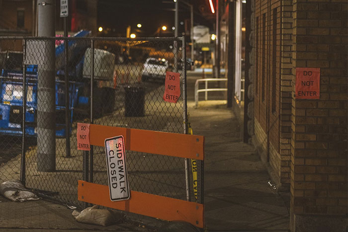 "Night scene with 'Do Not Enter' and 'Sidewalk Closed' signs, reflecting wild memories of bartenders."
