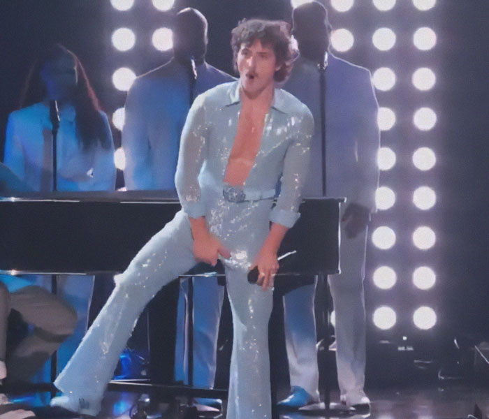 Performer in a sparkling outfit on stage at the 2025 Grammy Awards, captured in an awkward yet memorable moment.