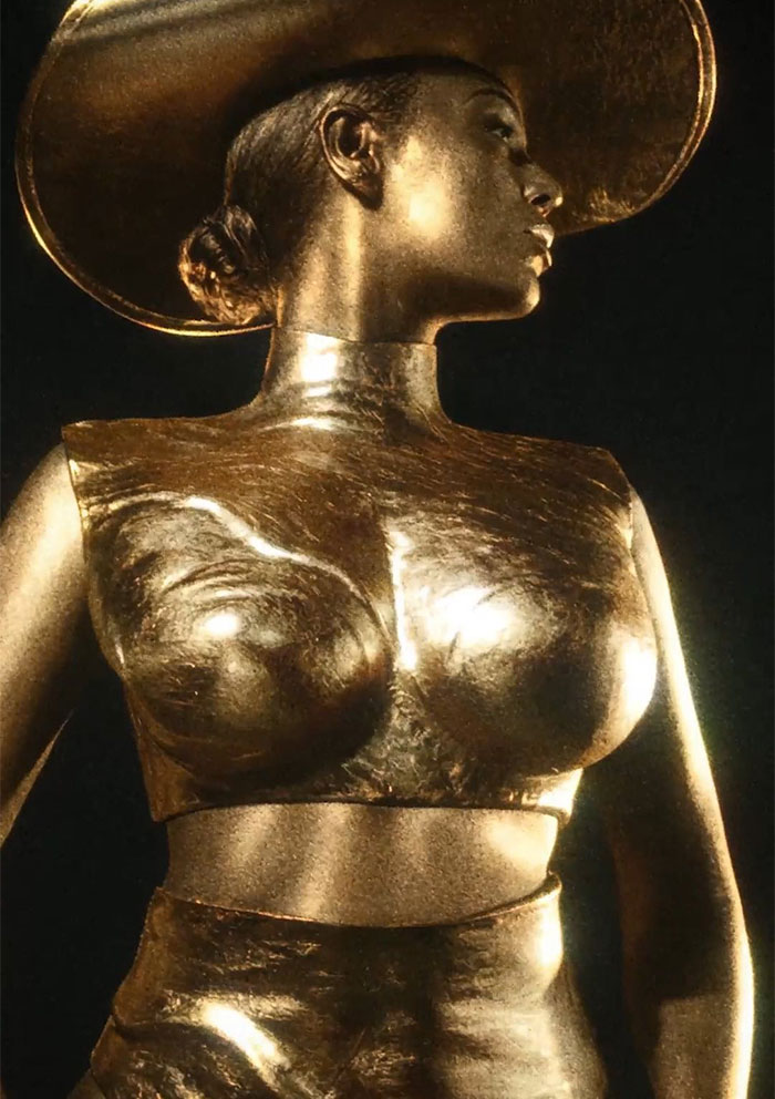 Gold-covered Beyonce in artistic pose wearing a hat, representing the criticized Ce Lumiere perfume ad.
