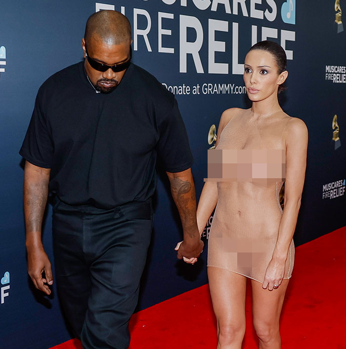 A man and a woman in a sheer dress at a red carpet event. A man and a woman in a sheer dress at a red carpet event.