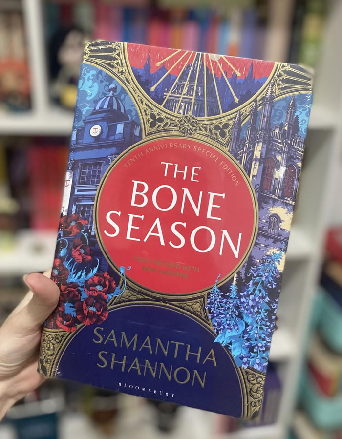 Cover of "The Bone Season" by Samantha Shannon held in a bookstore, suggested after binge-reading "Onyx Storm".