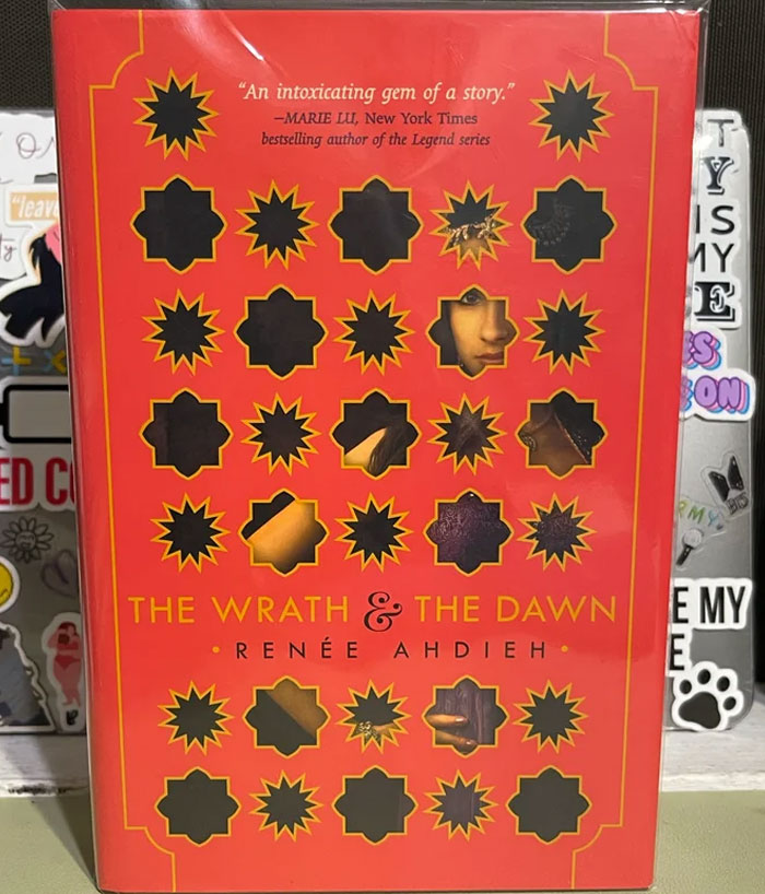 "The Wrath & The Dawn book cover on a colorful background, featuring intricate designs."