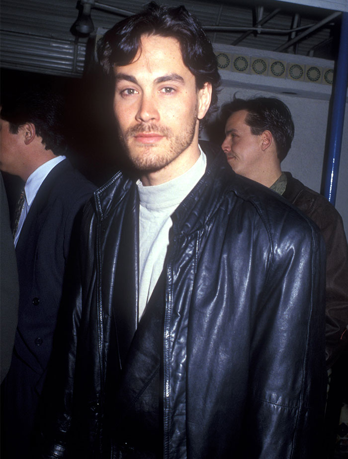 Young man in a black leather jacket at a public event, symbolizing a tragic celebrity passing.