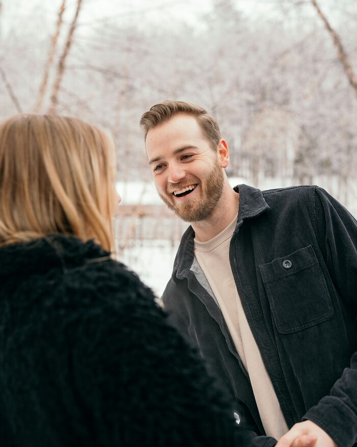 Man smiling at a woman in a snowy setting, capturing a moment of conversation about offensive remarks.