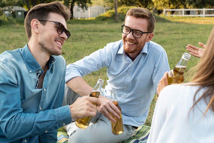 People outdoors enjoying a casual gathering, talking and smiling.