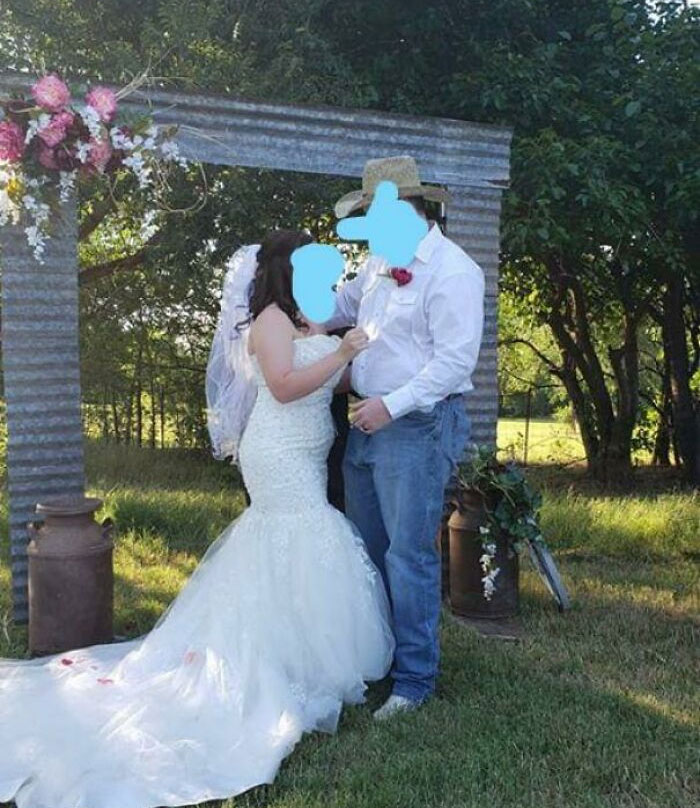 Bride and groom in casual attire under a rustic arch in a rural setting, representing budget wedding fails.
