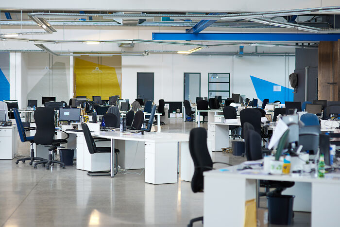 Open modern office with black chairs and multiple computer workstations, depicting workplace moments and legendary status.