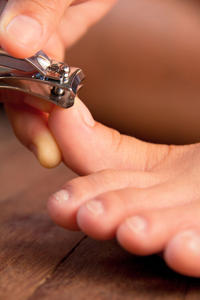 Close-up of a person clipping their toenails, an unexpected insane workplace moment captured in detail.