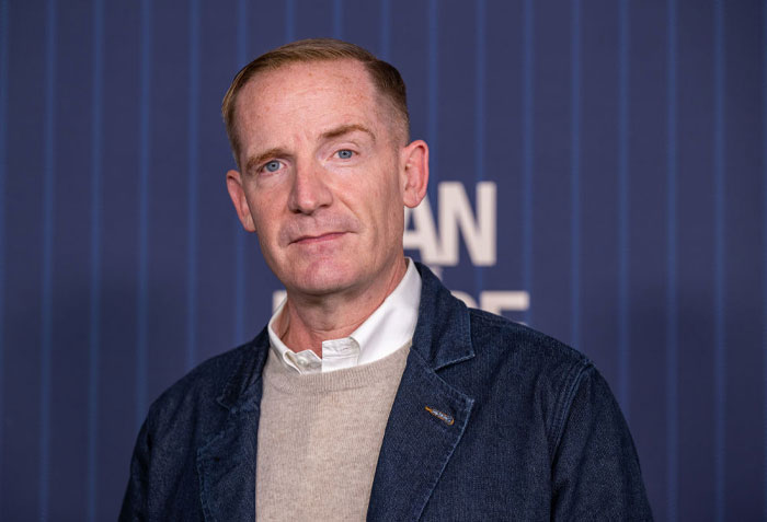 Marc Evan Jackson in a casual outfit poses for a portrait, associated with Netflix series "A Man On The Inside" cast alongside Ted Danson.
