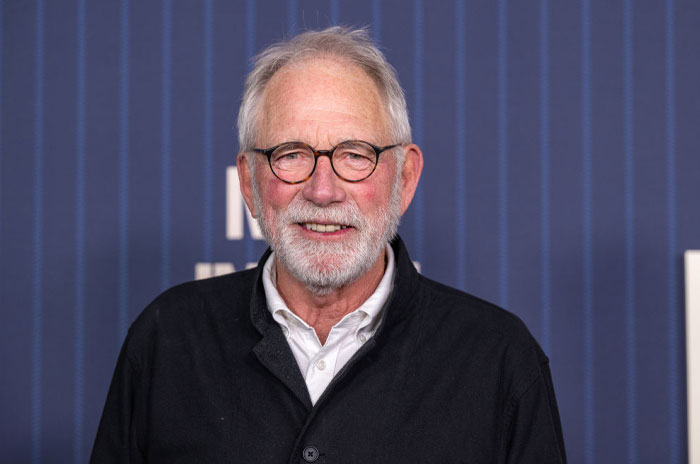 John Getz from A Man On The Inside cast posing at Netflix event in black jacket.
