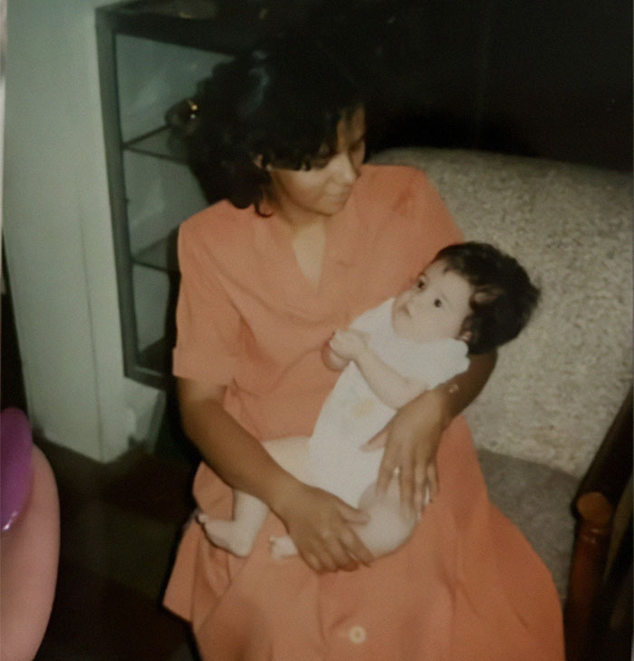 Woman in orange dress holding a baby, related to shady adoption story.