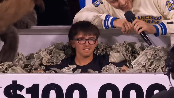 College student surrounded by cash after winning $100K in a shooting challenge. College student surrounded by cash after winning $100K in a shooting challenge.