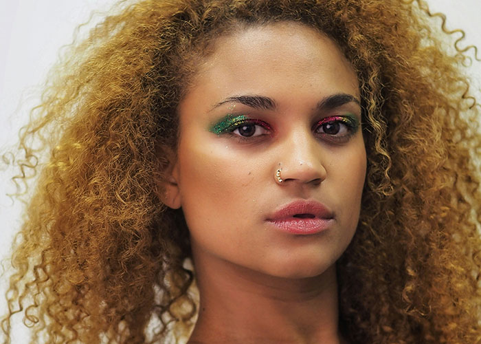 Mujer con maquillaje colorido y nariz con piercing, mostrando rasgos poco atractivos que resultan atractivos para algunos.