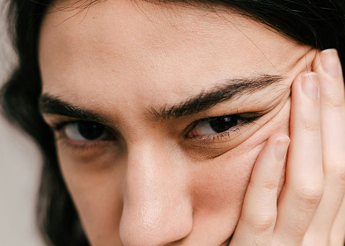 Close-up of a person's face with unique features, showcasing a contemplative expression.