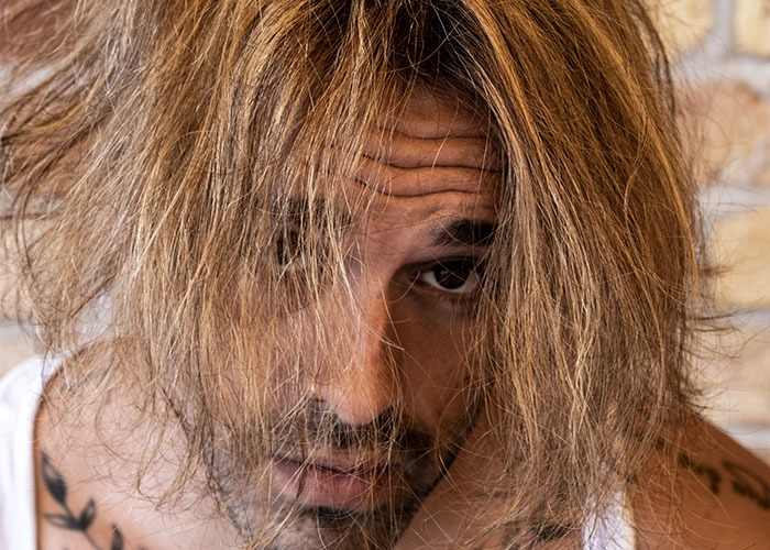 Person with long, messy hair, showcasing an "unattractive" feature that is uniquely appealing.