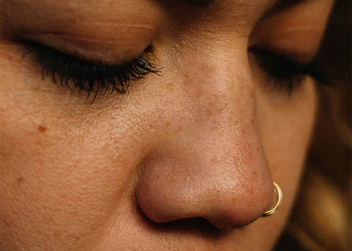 Primer plano del rostro mostrando rasgos poco atractivos que para algunas personas son lo contrario, con un piercing en la nariz.