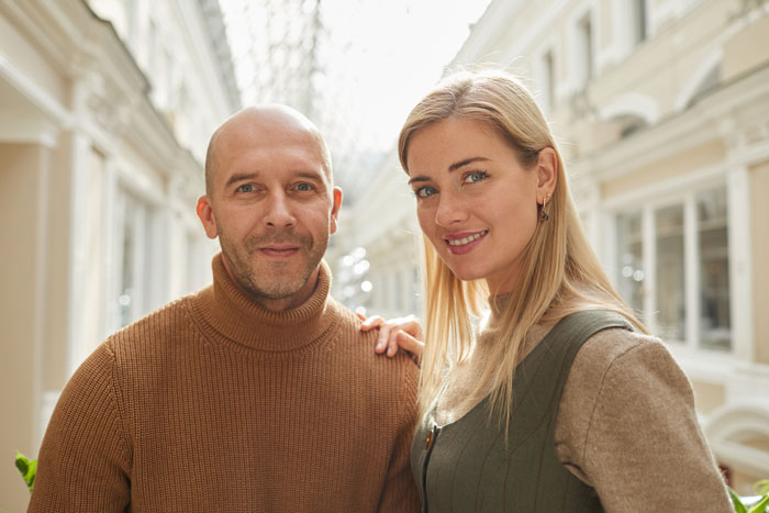 Man and woman posing together indoors, focusing on smiling and casual attire, relevant to theme of dad and girlfriend dynamics. Man and woman posing together indoors, focusing on smiling and casual attire, relevant to theme of dad and girlfriend dynamics.