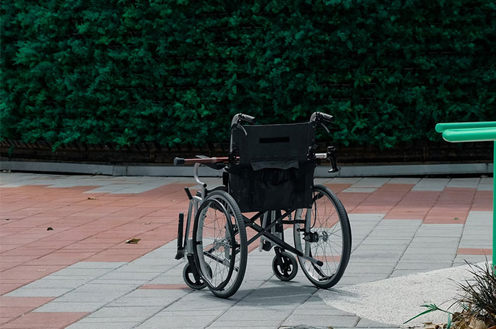 Empty wheelchair on a tiled path, symbolizing haunting stories and mysteries shared online.