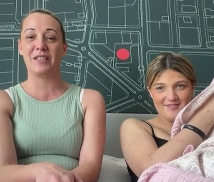 Two women smiling indoors with a map background, related to a medical case.