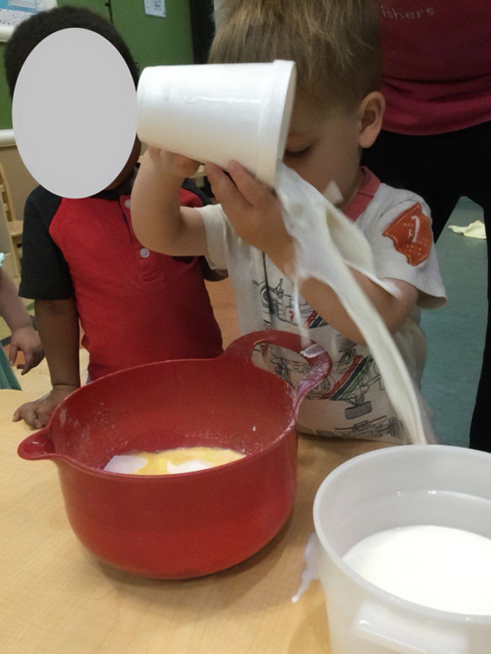Niños haciendo tonterías divertidas al jugar con vajilla y líquidos en clase.