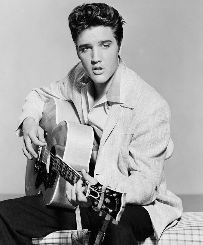 "Celebrity playing guitar in black and white, embodying a tragic and stunning legacy."