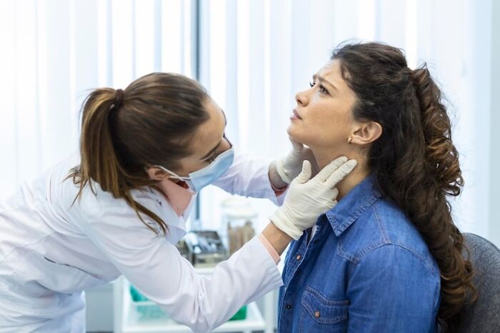 Doctor examining a woman's neck in a clinic setting, illustrating rare cosmetic procedures.